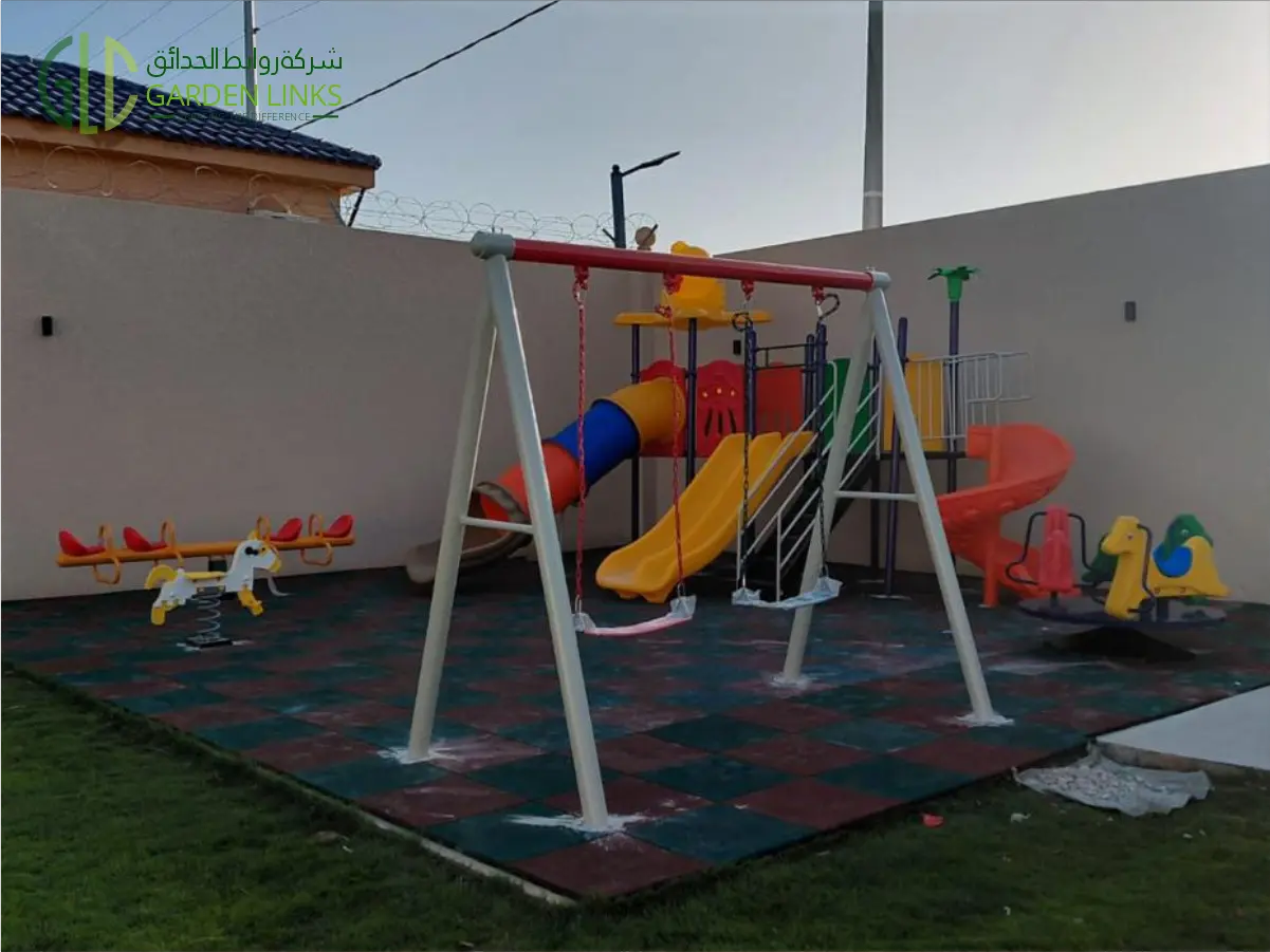 Residential villa playground installation in Al Bahah including slides, swing set, rubber flooring, benches, and park furniture by Garden Links.