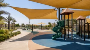 Saudi playground with shaded rubber flooring, lighter colour zones, and exposed areas under strong midday sunlight