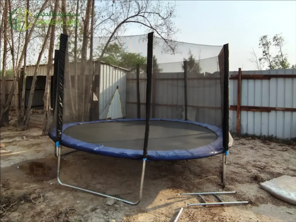Commercial outdoor trampoline with safety enclosure installed in Dammam, Saudi Arabia, featuring a galvanized steel frame and protective safety net by Garden Links.