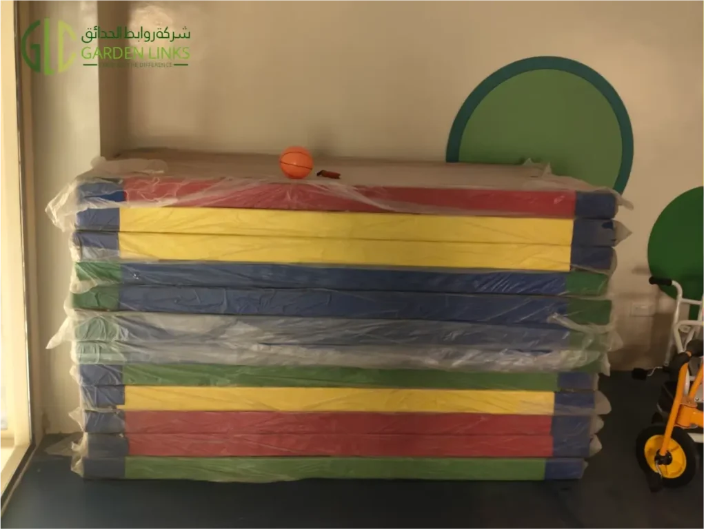 Stacked colorful gym mats for kids play area by Garden Links