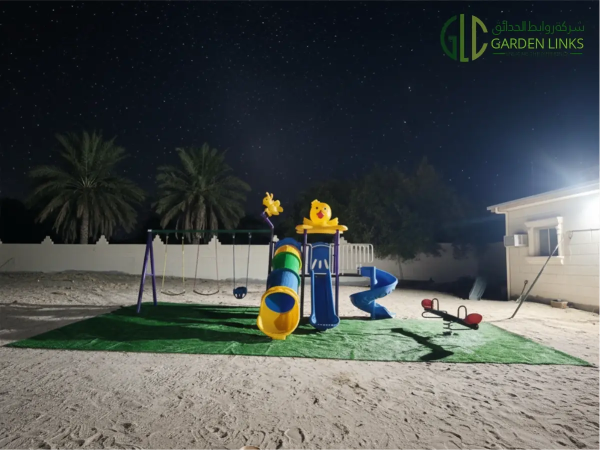 Outdoor playground equipment installed by Garden Links in As Sarrar, Saudi Arabia, featuring a multi-play structure, swings, seesaw, and artificial grass safety surfacing.