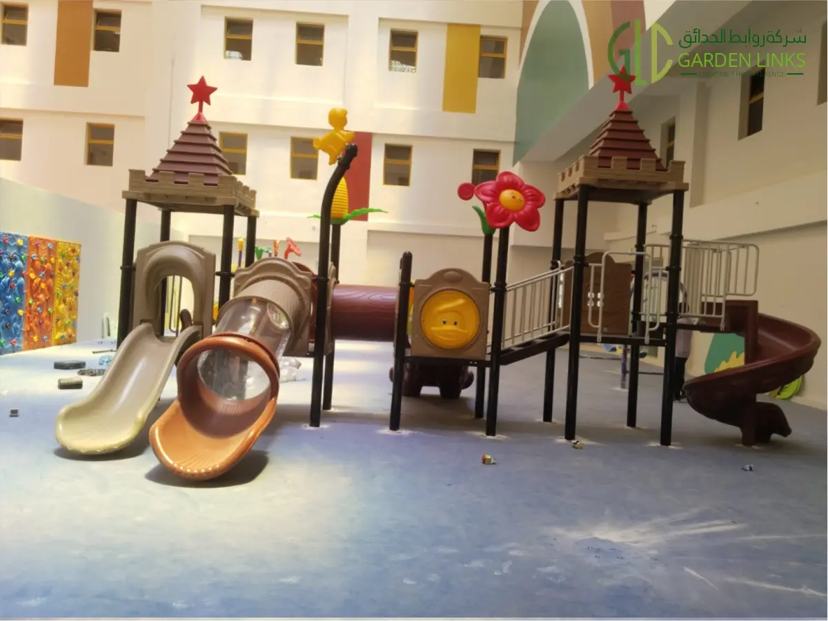 Indoor playground equipment featuring multiple slides, climbing structures, play towers, tunnels, and colorful decorative elements.