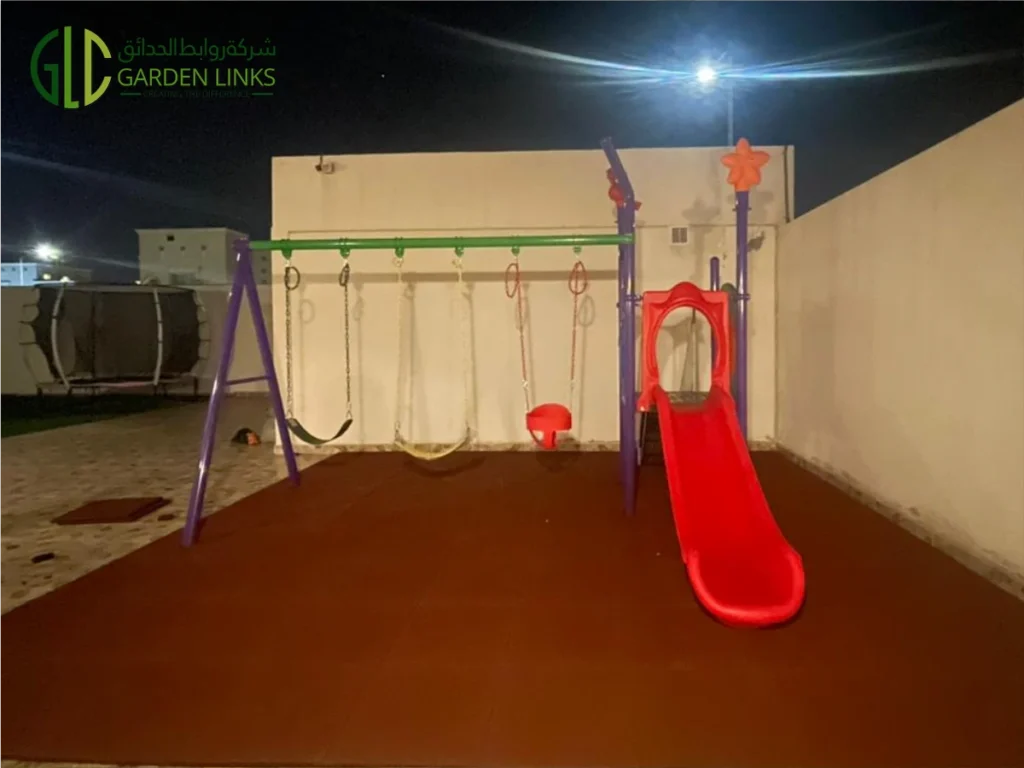 Purple playground frame with red slide, multiple swing seats, and soft-fall rubber flooring on a villa rooftop