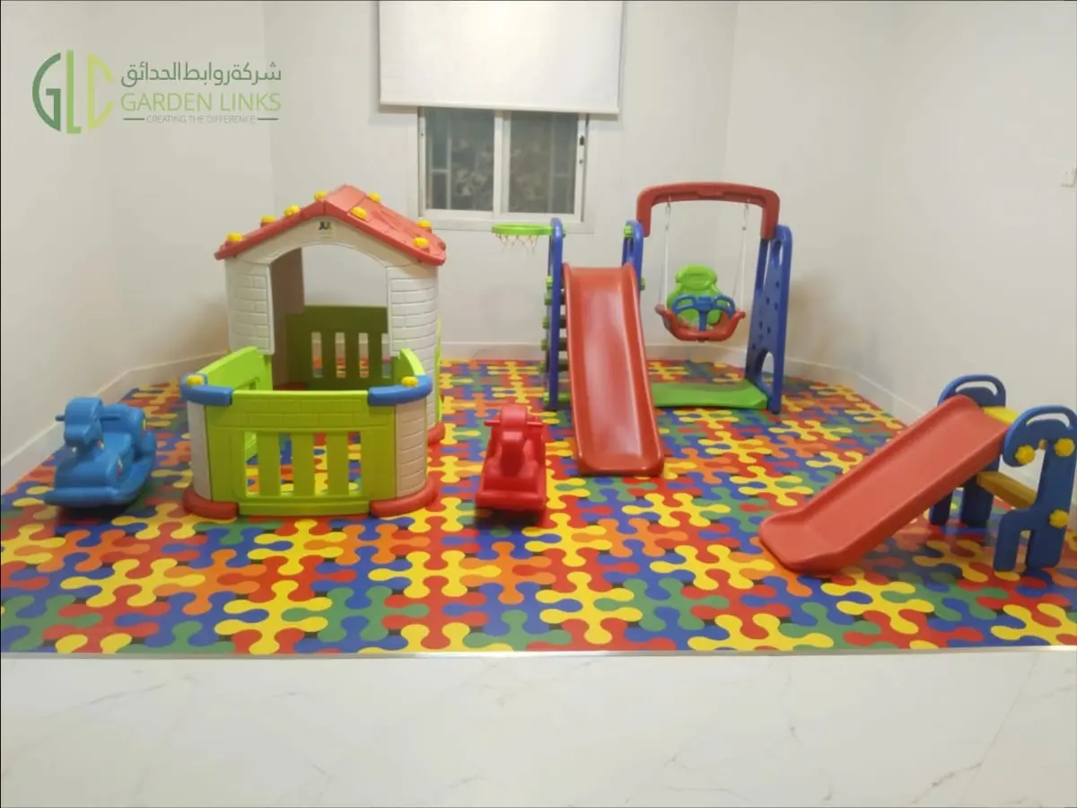 Indoor school play area in Riyadh with children’s playhouse, slides, swing, rocking toys and colourful interlocking play flooring.