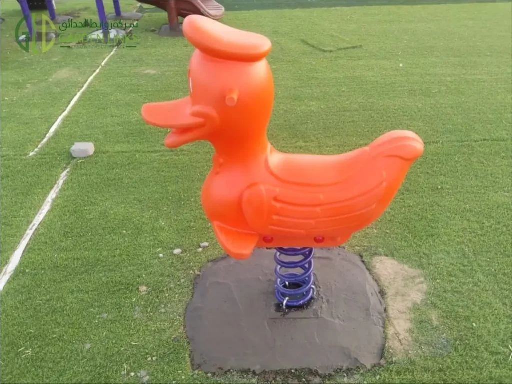 Duck-themed spring rider with steel spring base installed at a public park playground in Madinah, Saudi Arabia.