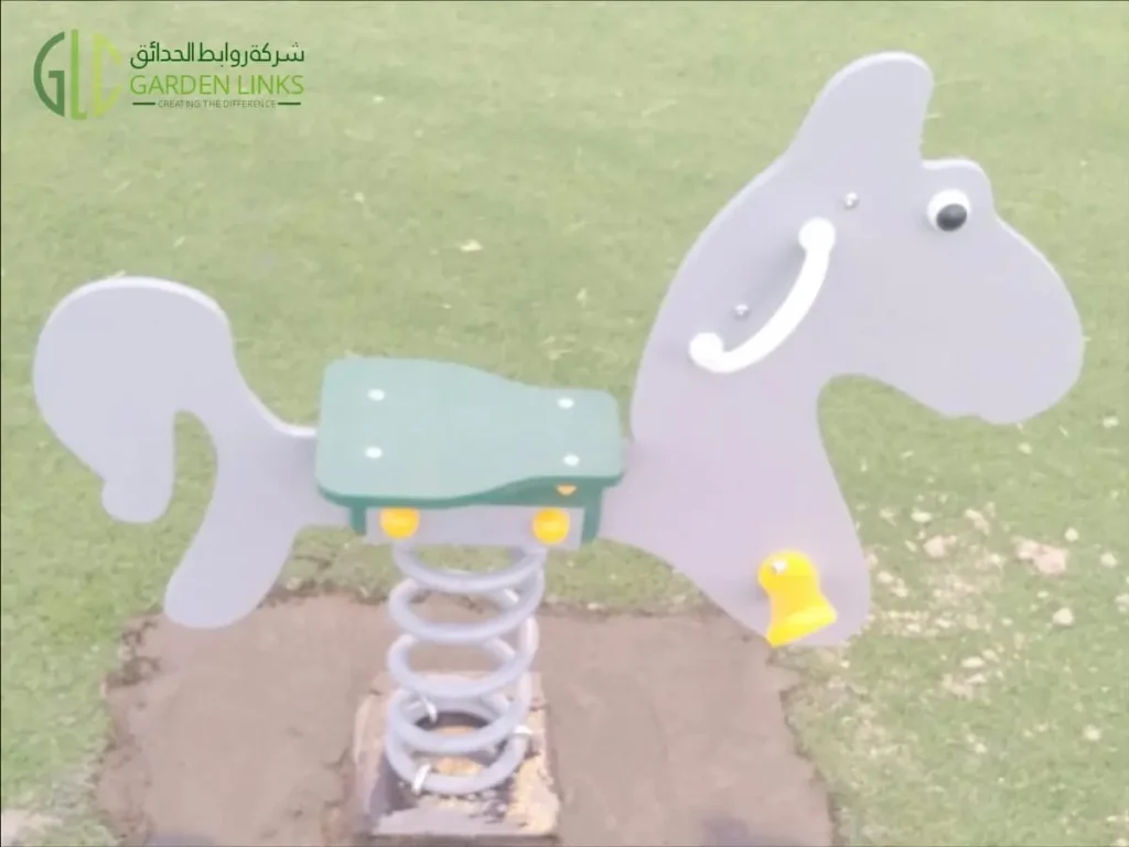 Horse-shaped spring rocker installed on artificial grass as part of a public park playground equipment project in Madinah.