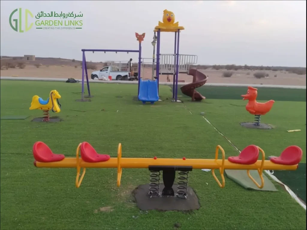 Public park playground equipment installation in Madinah featuring a four-seat seesaw, horse and duck spring riders, slides and a multi-activity structure.