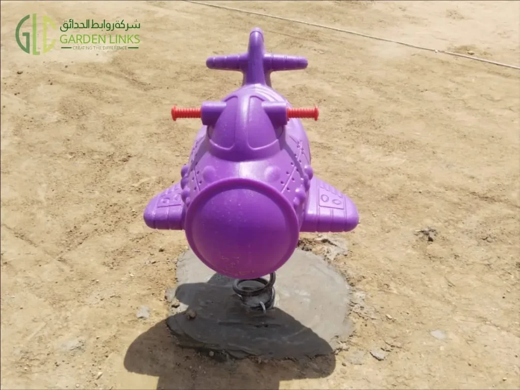 لعبة زنبركية للأطفال بتصميم طائرة مركبة في حديقة عامة بالمدينة المنورة، المملكة العربية السعودية.