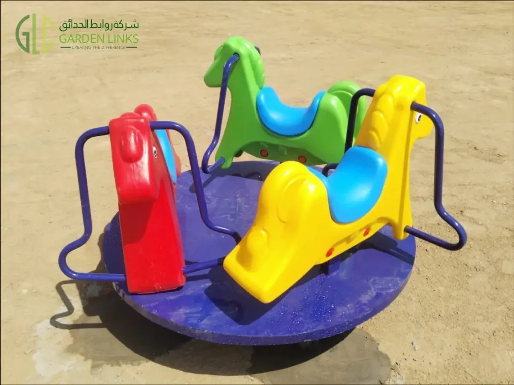 لعبة دوارة للأطفال بمقاعد ملونة على شكل خيول مركبة في حديقة عامة بالمدينة المنورة.