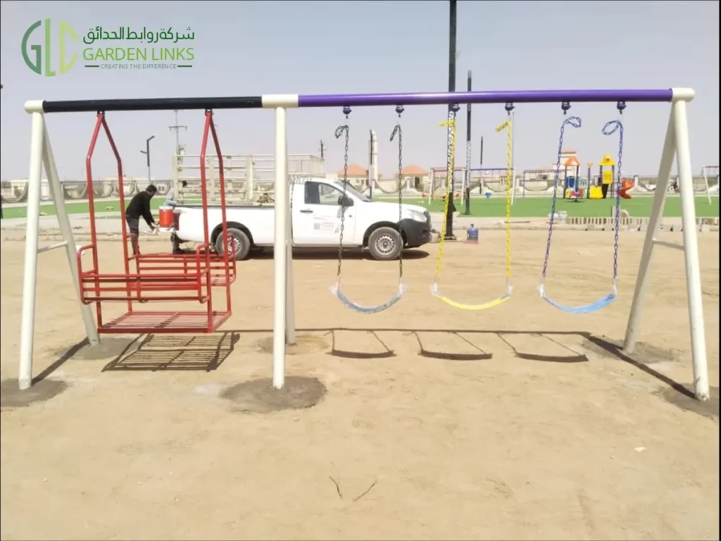 مجموعة مراجيح متعددة المقاعد تضم مرجيحة بمقعد طويل ومقاعد مراجيح عادية في حديقة عامة بالمدينة المنورة.
