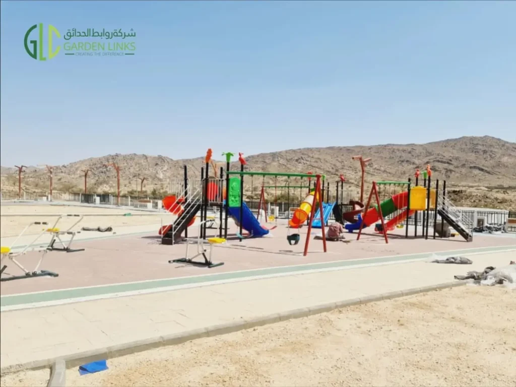 Public park playground and outdoor fitness equipment installed in Taala, Saudi Arabia, with slides, swings and exercise stations.