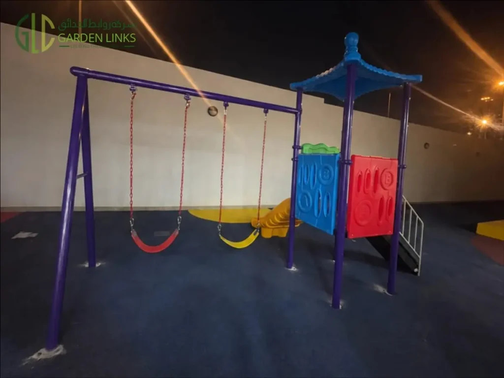 Kindergarten playground installation in Riyadh with a two-seat swing set, elevated play tower, access stairs and rubber safety flooring in Al Yasmin.