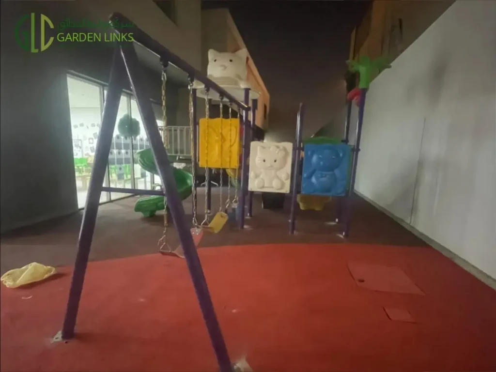 Kindergarten playground installation in Riyadh with two-seat swing set, elevated play structure and rubber safety flooring in Al Yasmin.