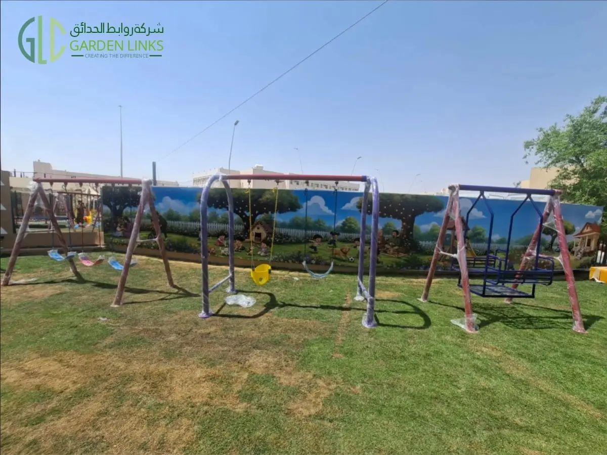 تركيب ألعاب حديقة عامة في الخرج مع عدة مجموعات من مراجيح الأطفال، ومقعد مرجيحة للأطفال الصغار، ومعدات ألعاب خارجية.