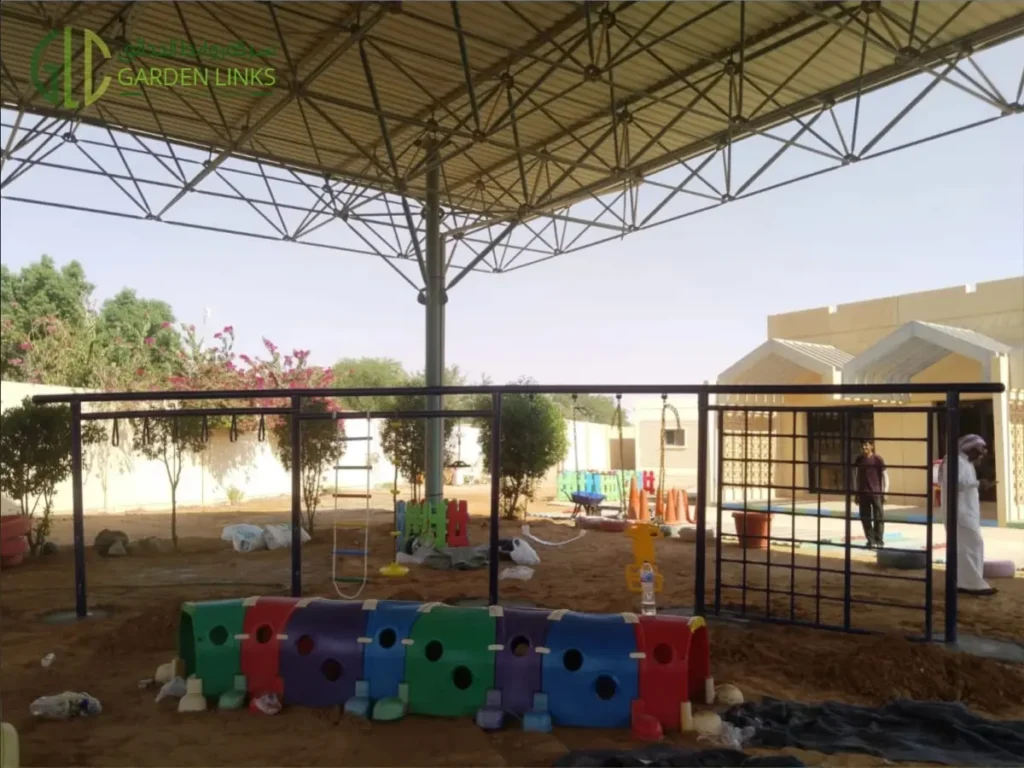 Outdoor kindergarten playground in Dahiat Namar, Riyadh with multi-play structure, climbing equipment, toddler swing and play tunnel.