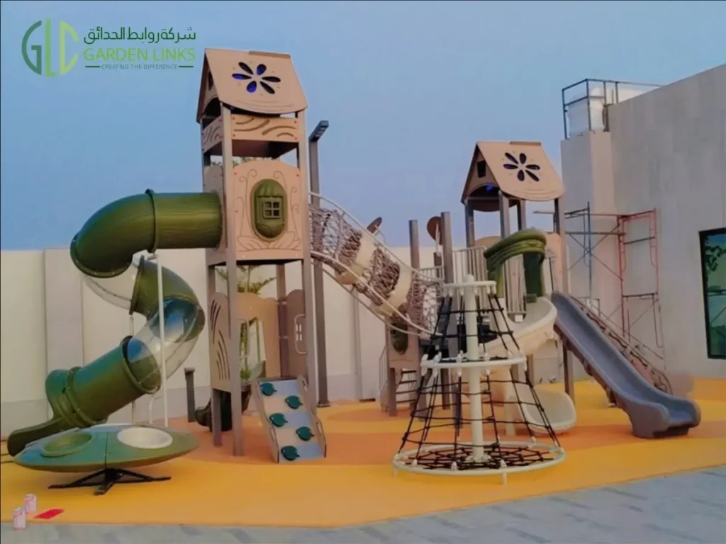 Outdoor resort playground in Riyadh featuring an enclosed tube slide, open slides, rope climber, climbing wall and elevated towers.