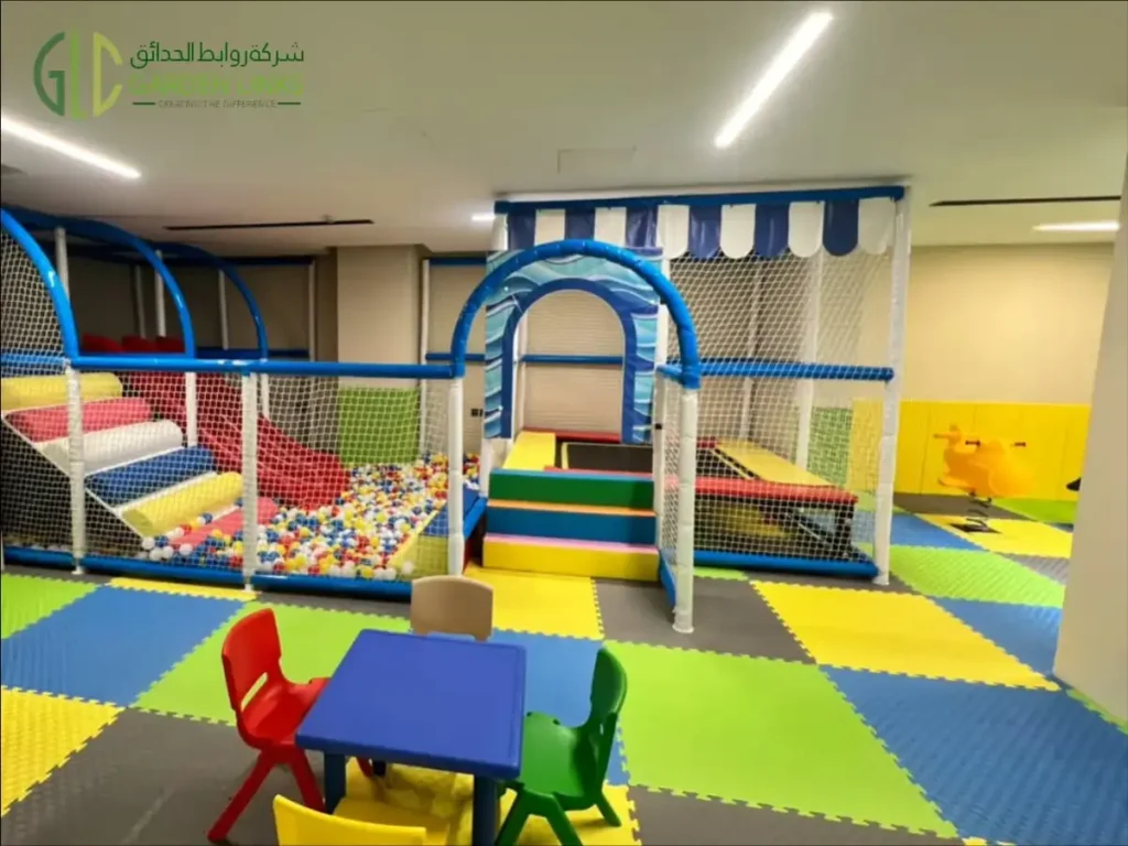 Indoor soft-play structure with a ball pool, padded steps, mesh enclosure and children’s table and chairs.