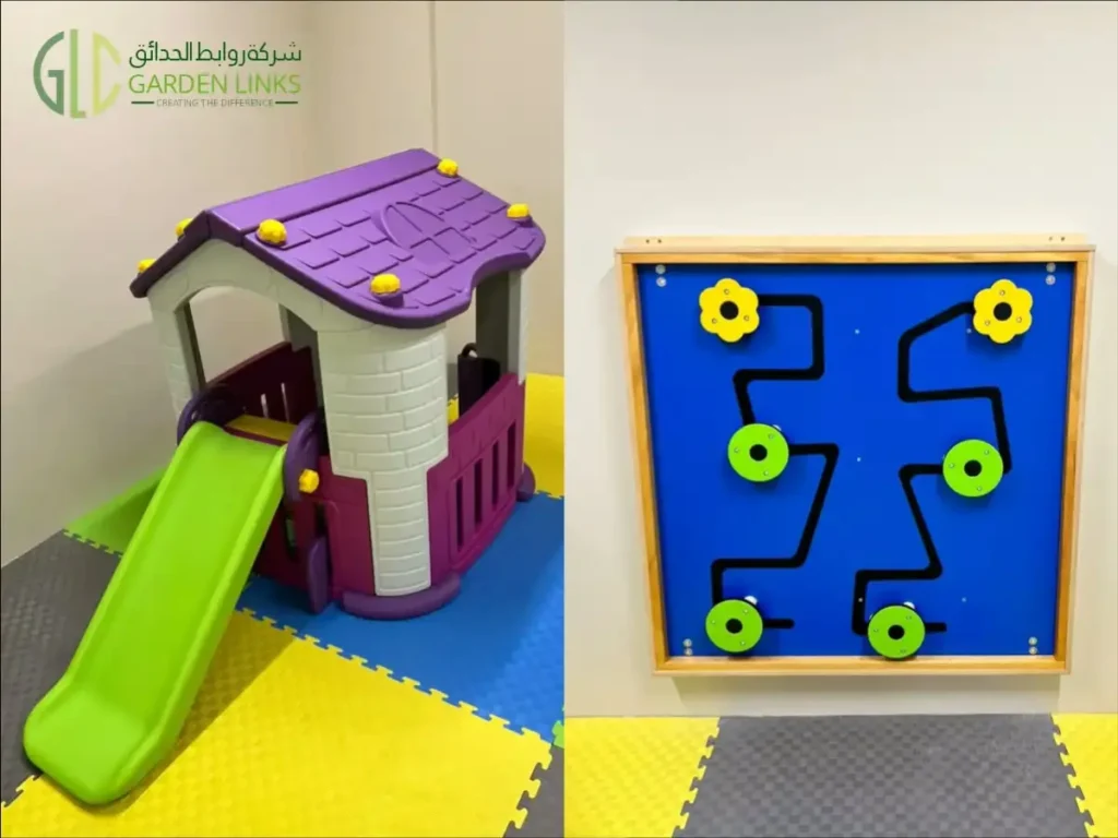 Toddler playhouse with a purple roof and green slide beside a blue wall-mounted activity panel.