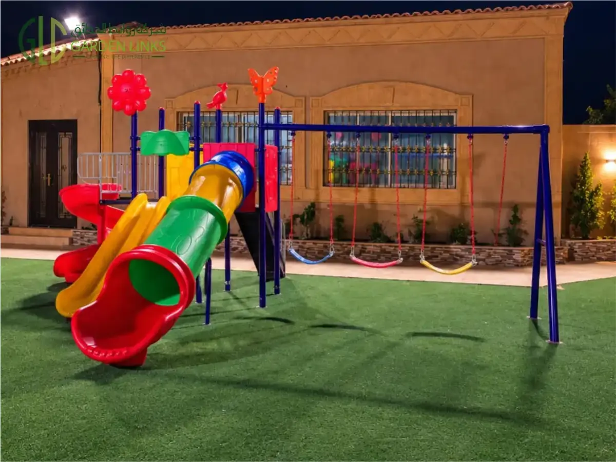 تركيب ألعاب أطفال بمنزل خاص في الحلوة، مع زحاليق ملونة وثلاث مراجيح وعشب صناعي بجوار المنزل.