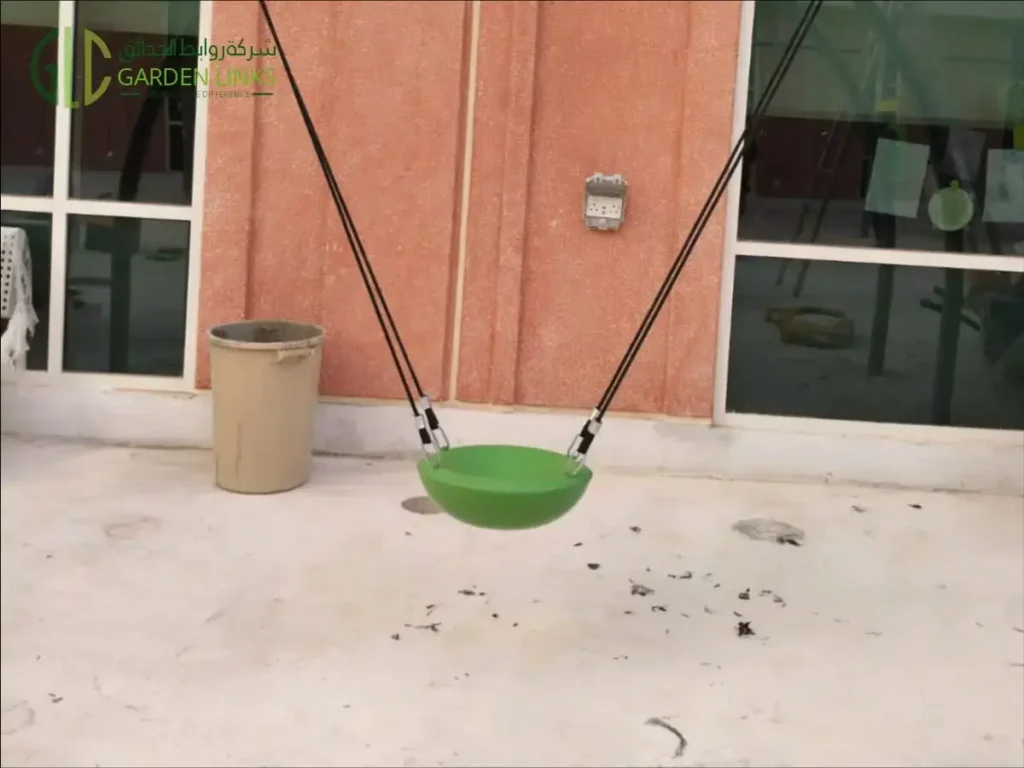 Aramco School Playground Al Ahsa green suspended seat with black suspension lines and metal connectors.